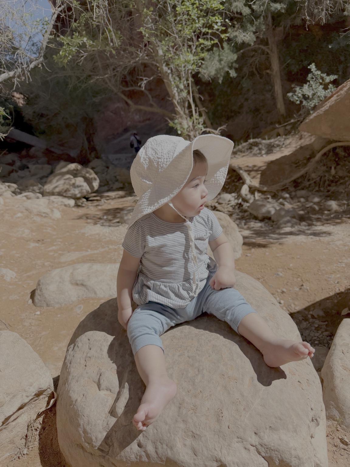 Delina outdoors in a white sun hat