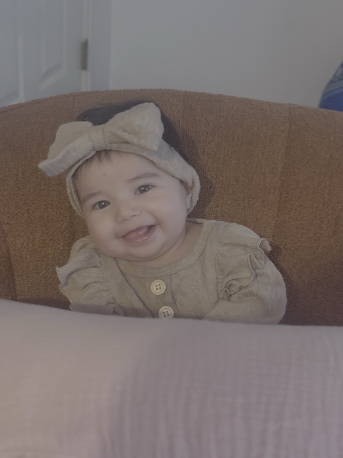 Delina smiling in a chair