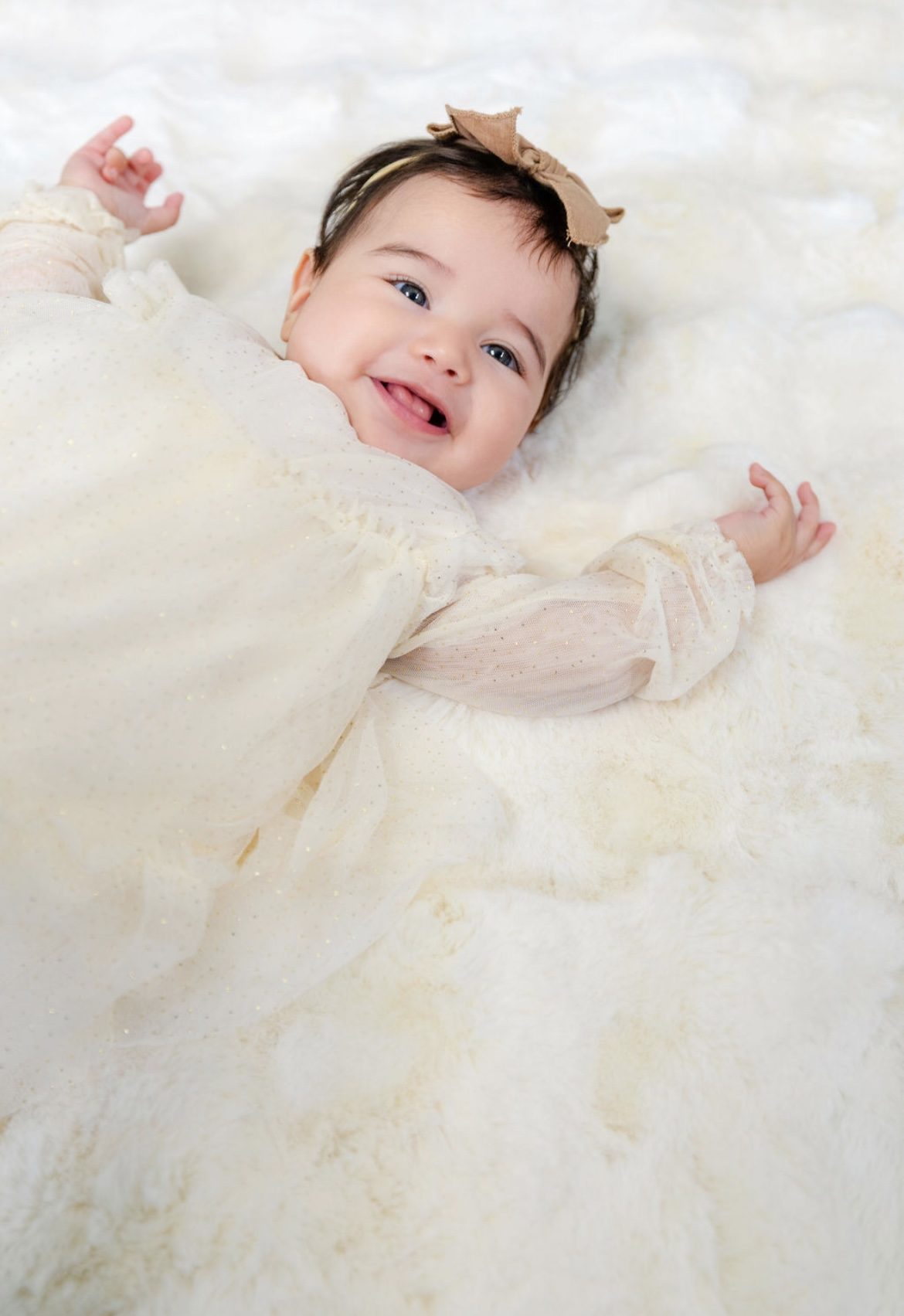 Delina smiling in a white dress